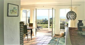 A room with a dining area, a view of the outdoors, and a hanging light fixture. - Close to the sea, quiet location, pool and sauna - Reethaus Göhren FeWo 01 (Göhren)