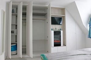 Une chambre à coucher avec un lit, une armoire et un téléviseur encastré.