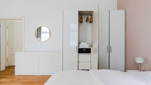 Een slaapkamer met een bed, een kledingkast, een spiegel en een nachtkastje.