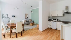 Een modern appartement met een eethoek, een bank, een keuken en uitzicht op de stad.