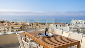 A wooden table with a bottle of champagne and glasses on a balcony overlooking a city and the sea. - Marinsa Beach,3 bed penthouse (Llanos, Los (Torrox-Costa))