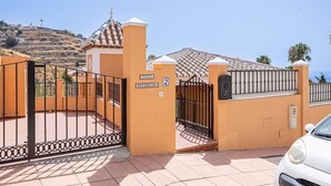 A gated villa with a tiled roof, a small tower, and a sign indicating the number 2. - Private villa in Tamango Hill (Torrox)