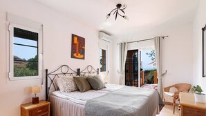 A bedroom with a bed, nightstand, and a view of the outdoors. - Private villa in Tamango Hill (Torrox)