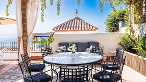 A round table with chairs, a sofa, and a view of the sea. - Luxurious villa in Tamango Hill (Torrox)