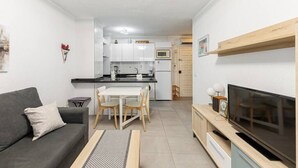 A compact living space with a kitchenette, a dining area, a sofa, and a TV. - Albaida, 1 bedroom with balcony (Nerja)