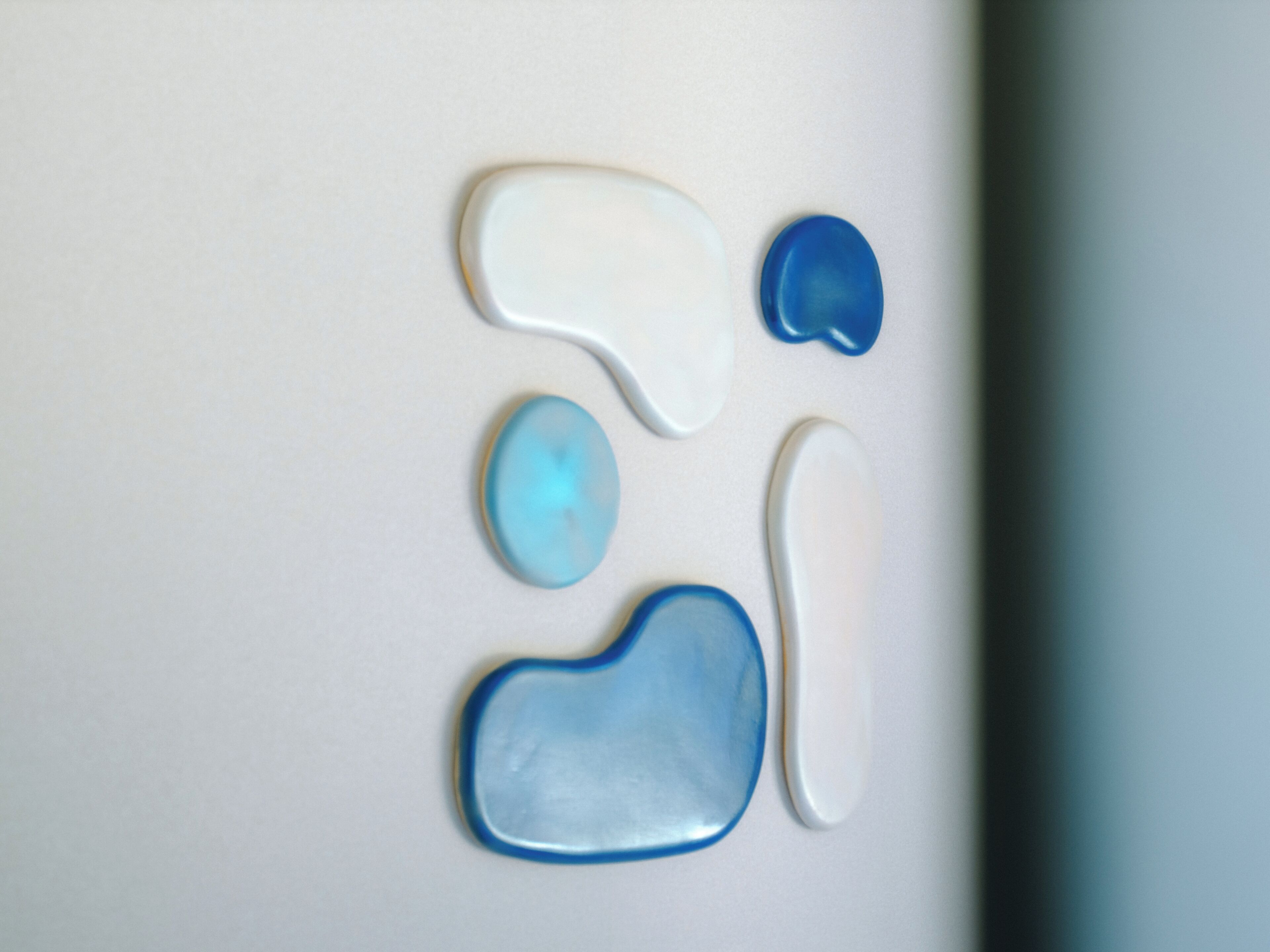 A white surface with four blue and white objects.