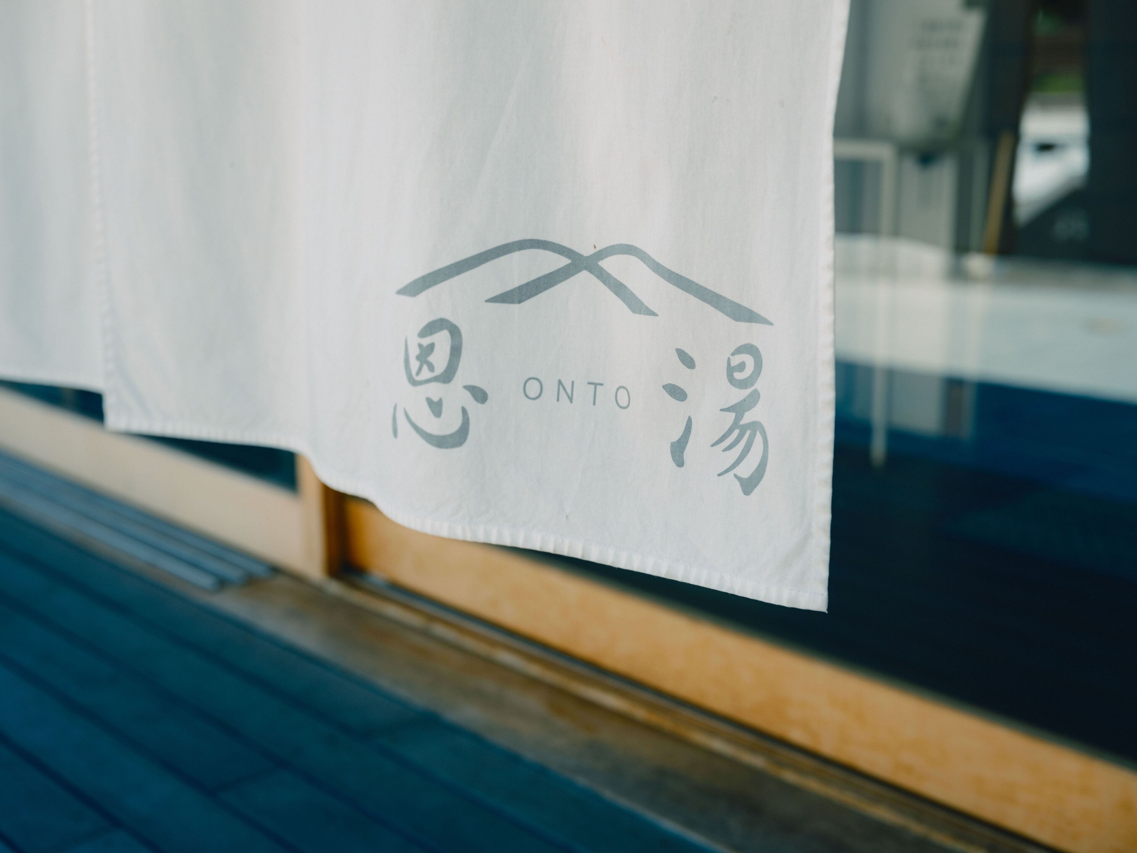 Un tessuto bianco con un logo e del testo, appeso davanti a una finestra.