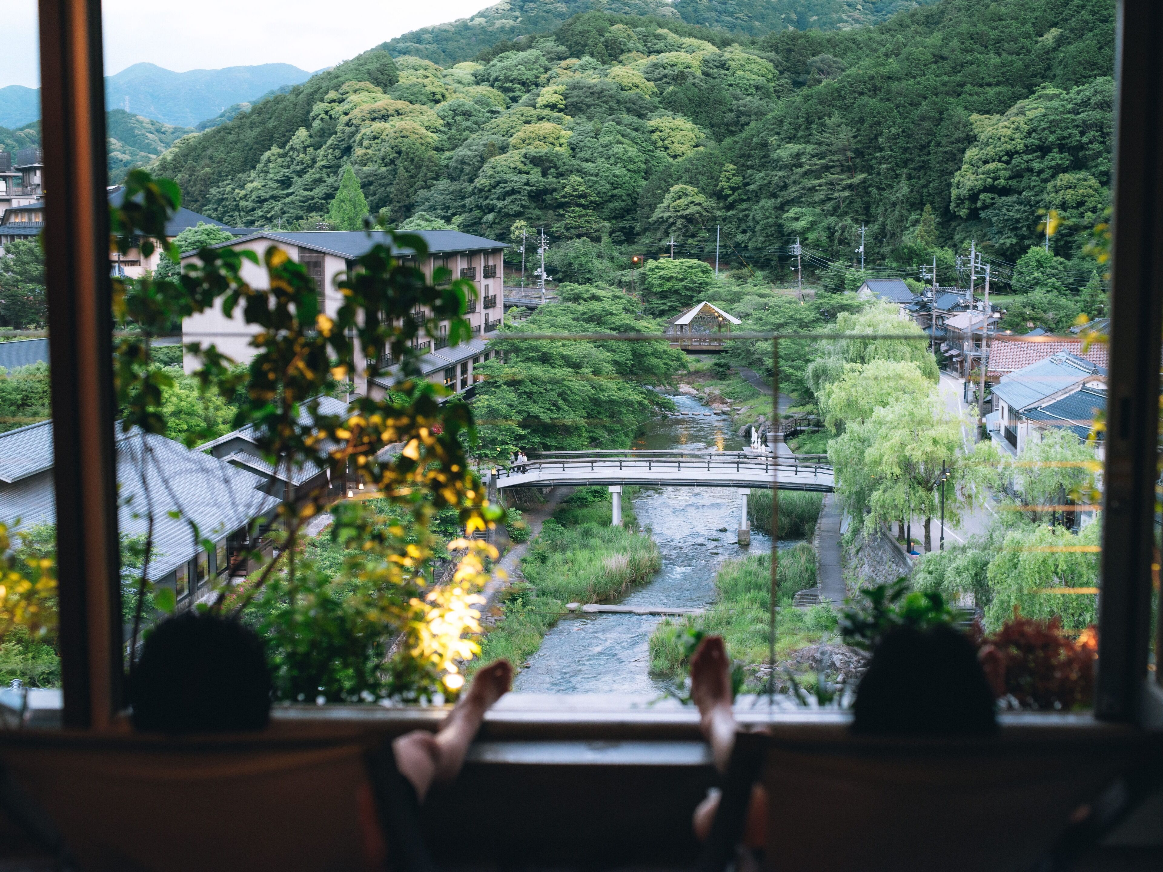 A view from a window overlooking a river, houses, and a bridge.