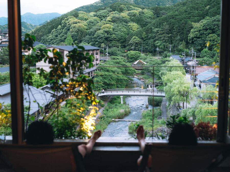 A view from a window overlooking a river, houses, and a bridge.