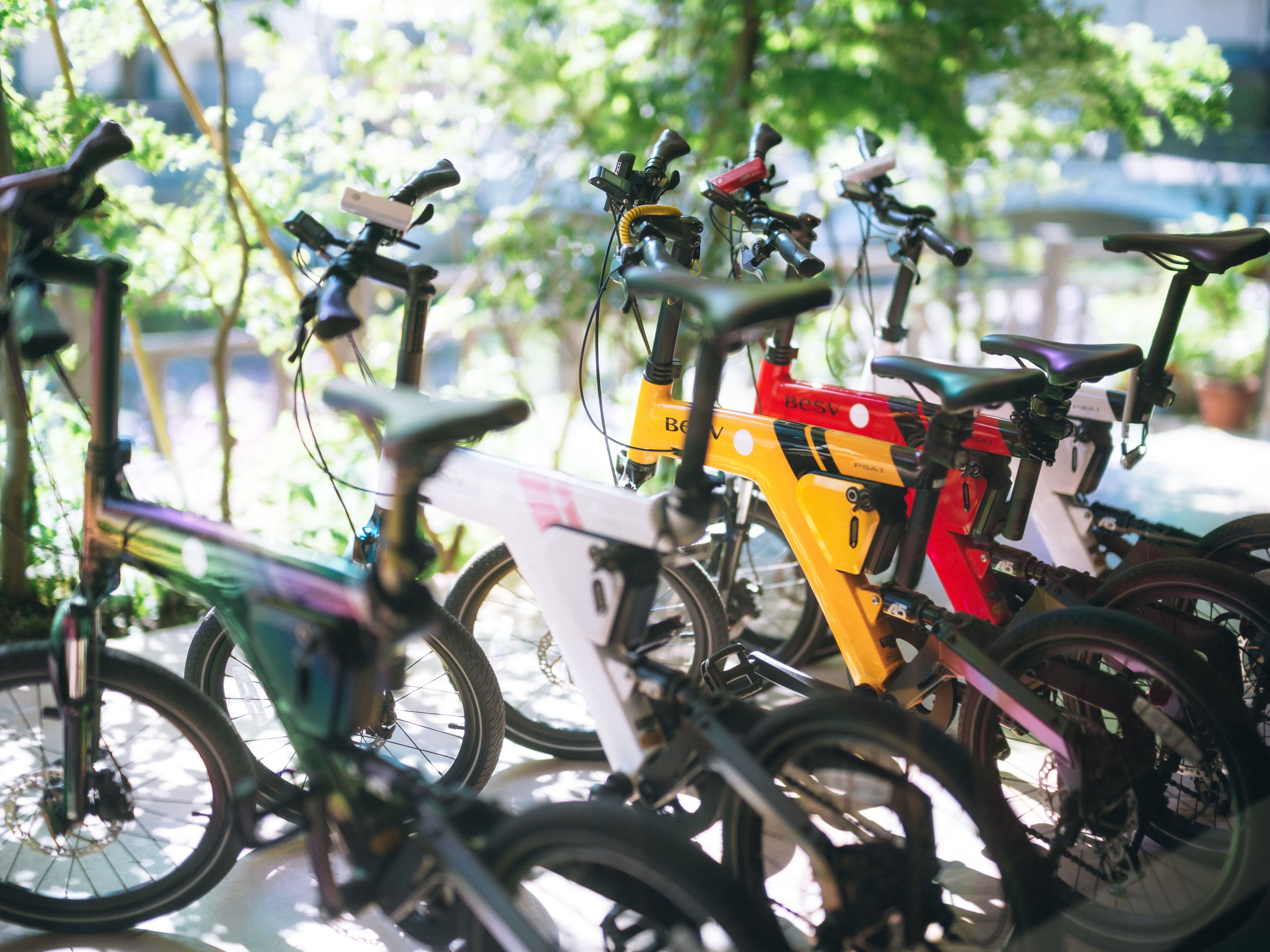 A row of bicycles parked outdoors, likely in a public or shared space.