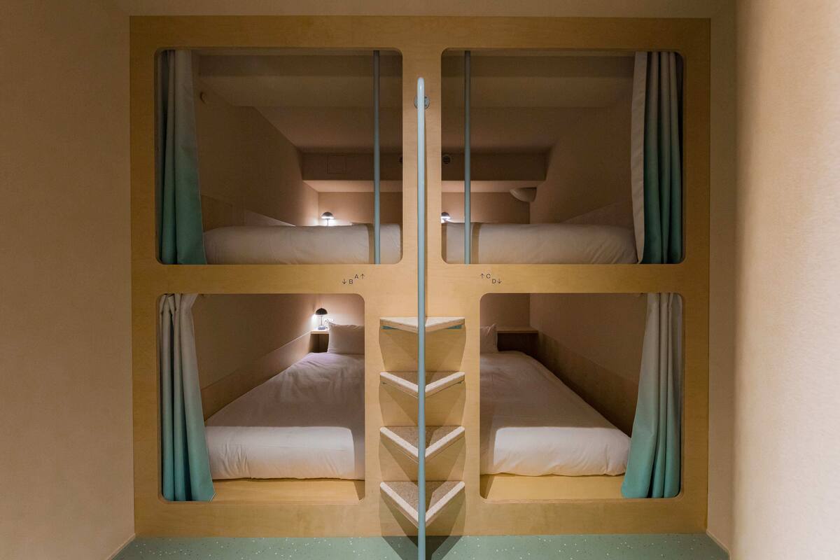 A bunk bed room with two beds and a ladder in the center.
