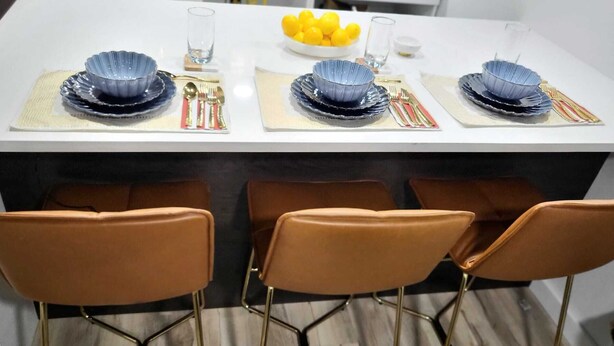 A dining table set with blue bowls, gold cutlery, and yellow lemons. - Romantic Hide Out
 (Stamford)