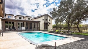 A swimming pool with a grill and lounge chairs, surrounded by a stone patio and a fenced area with trees. - Welcome to Little Blanco! Bonus: Free Golf During Your Stay! (Concan)
