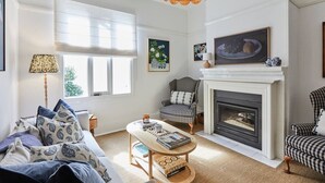 A living room with a fireplace, a sofa, a coffee table, and a lamp.