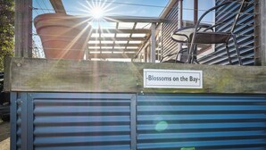 A sign reading "Blossoms on the Bay" above a blue metal gate. - Blossoms on the Bay - Nubeena (Nubeena)