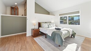 A bedroom with a bed, nightstand, and a window with a view. - Blossoms on the Bay - Nubeena (Nubeena)