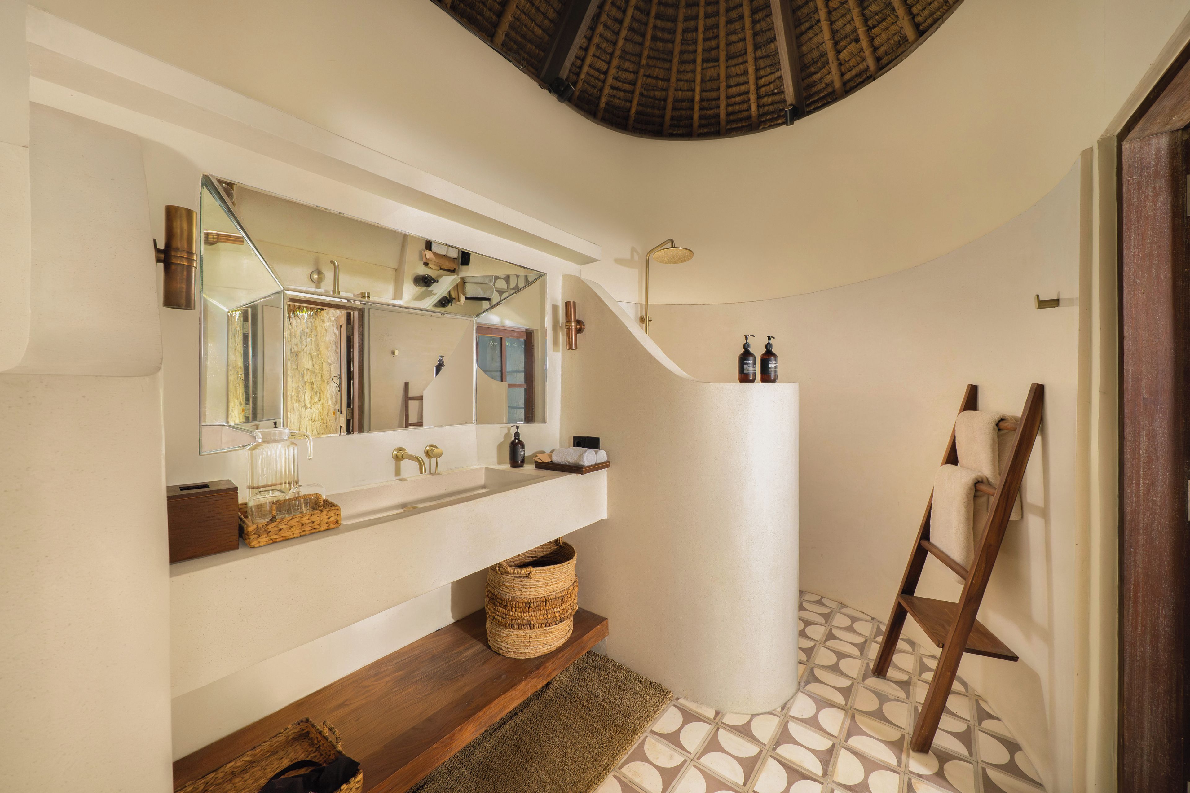 A bathroom with a large mirror, a shower, and a wooden ladder.