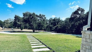 A pathway leading to a building with a stone wall. - Near Chandelier of Gruene, Downtown & Whitewater – Game Room, Fire Pit & More! (New Braunfels)