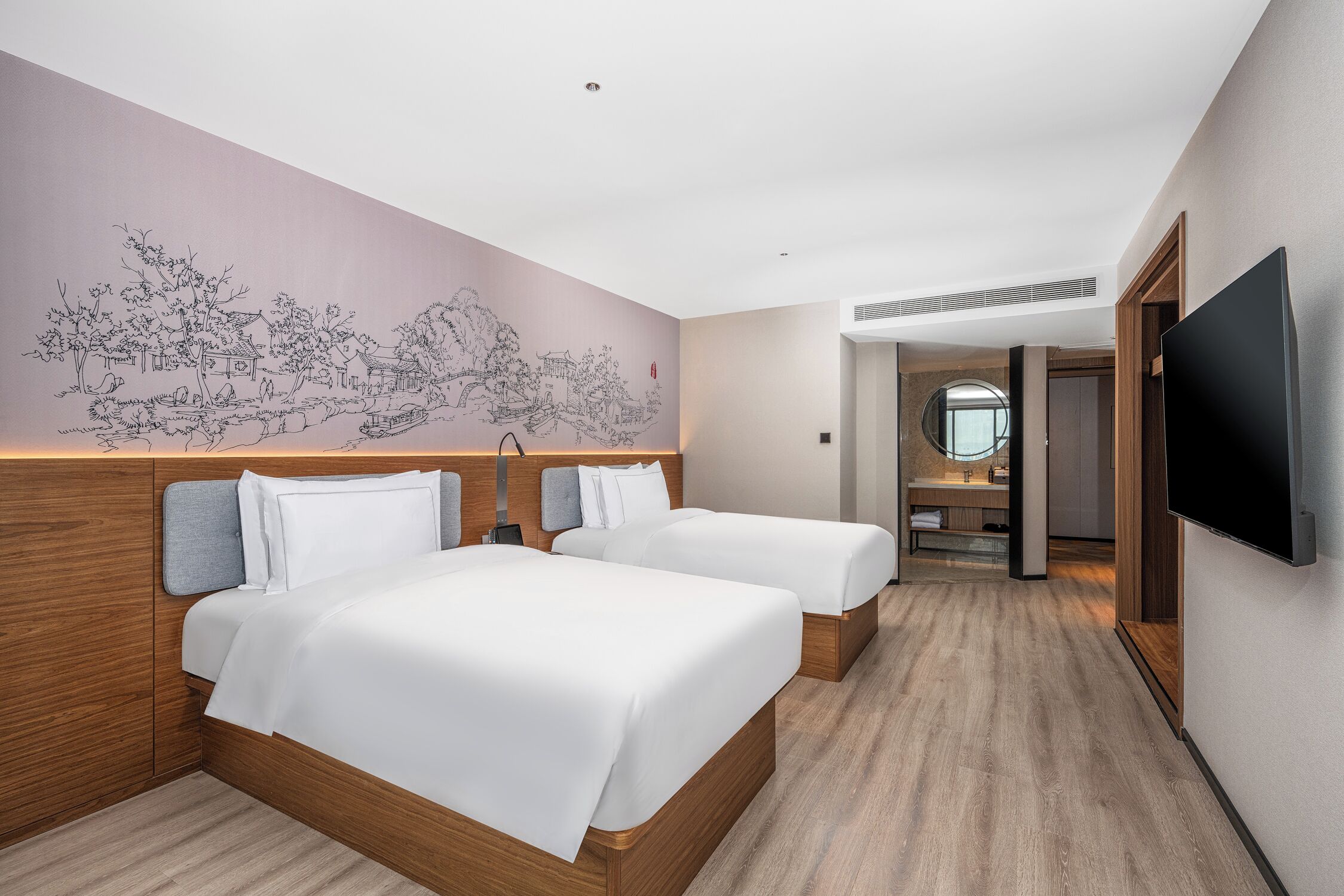 Habitación de hotel con dos camas, un mural grande en la pared y un televisor montado.