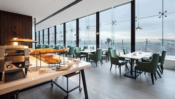 A modern dining area with a coffee machine, buffet, and seating. - UrCove by Hyatt Suzhou Shantang Street (Suzhou)