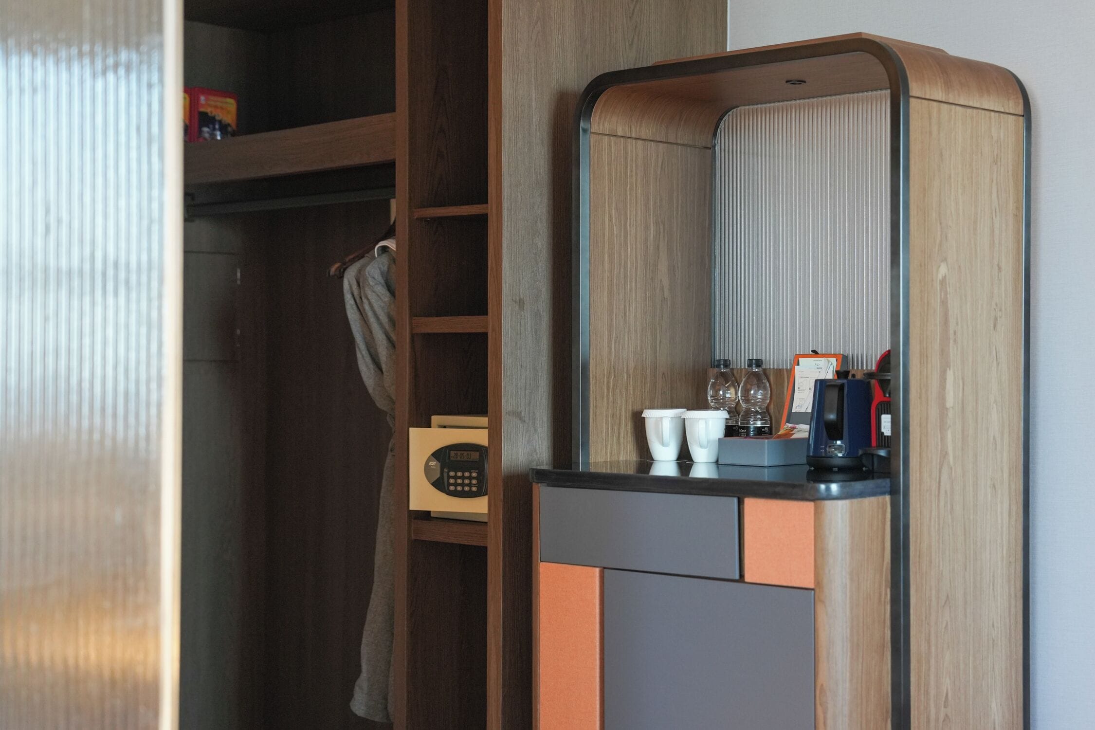 A modern bathroom with a wooden vanity, a mirror, and a towel rack.
