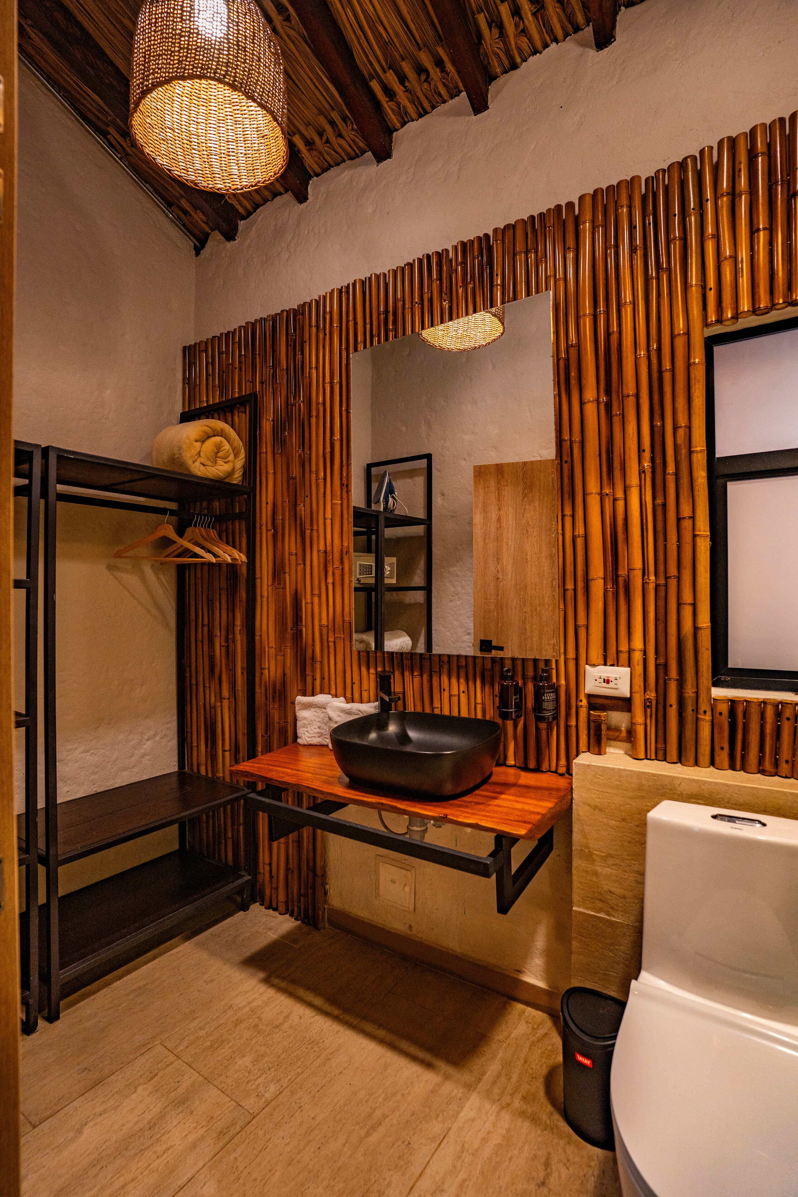 A bathroom with a wooden vanity, a large mirror, and a modern sink.
