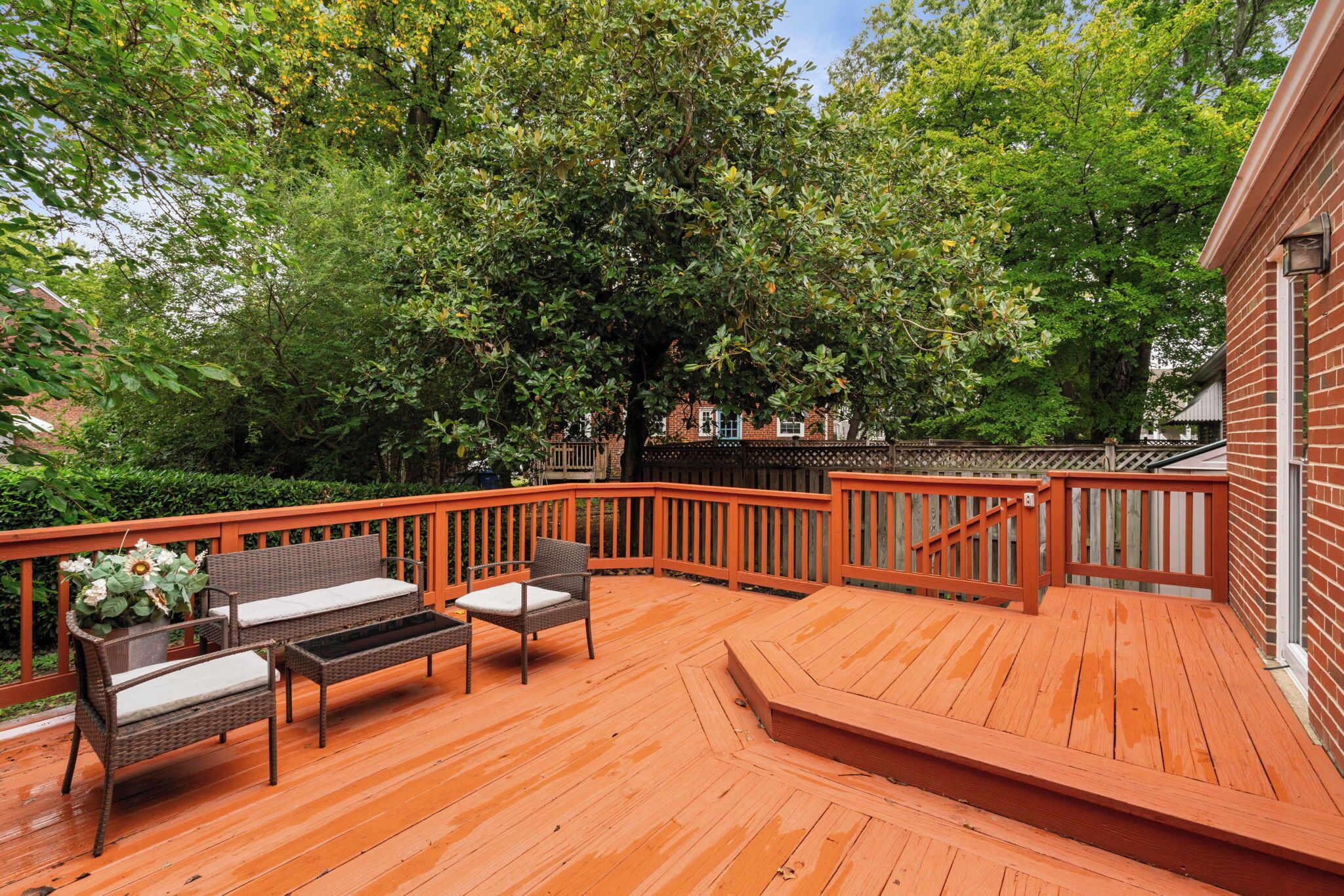 Eine Holzterrasse mit integriertem Bank und Tisch, umgeben von einem Holzgeländer.