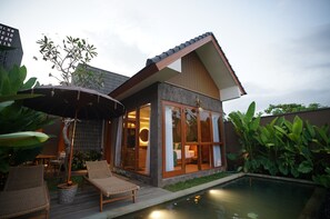 A modern house with a pool, large windows, and a patio with lounge chairs. - The Shanti Graha Villas (Sukawati)