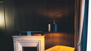 A hotel room with a bed, a desk with a computer, a chair, a fireplace, and a window with curtains. - Villa37 (Limoges)