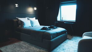 A dimly lit room with a bed, a desk, and a window. - Villa37 (Limoges)