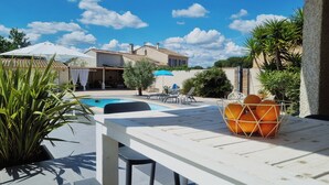 A poolside area with a table, chairs, and a fruit bowl. - Superb villa with a private pool (Saint-Nazaire-d'Aude)