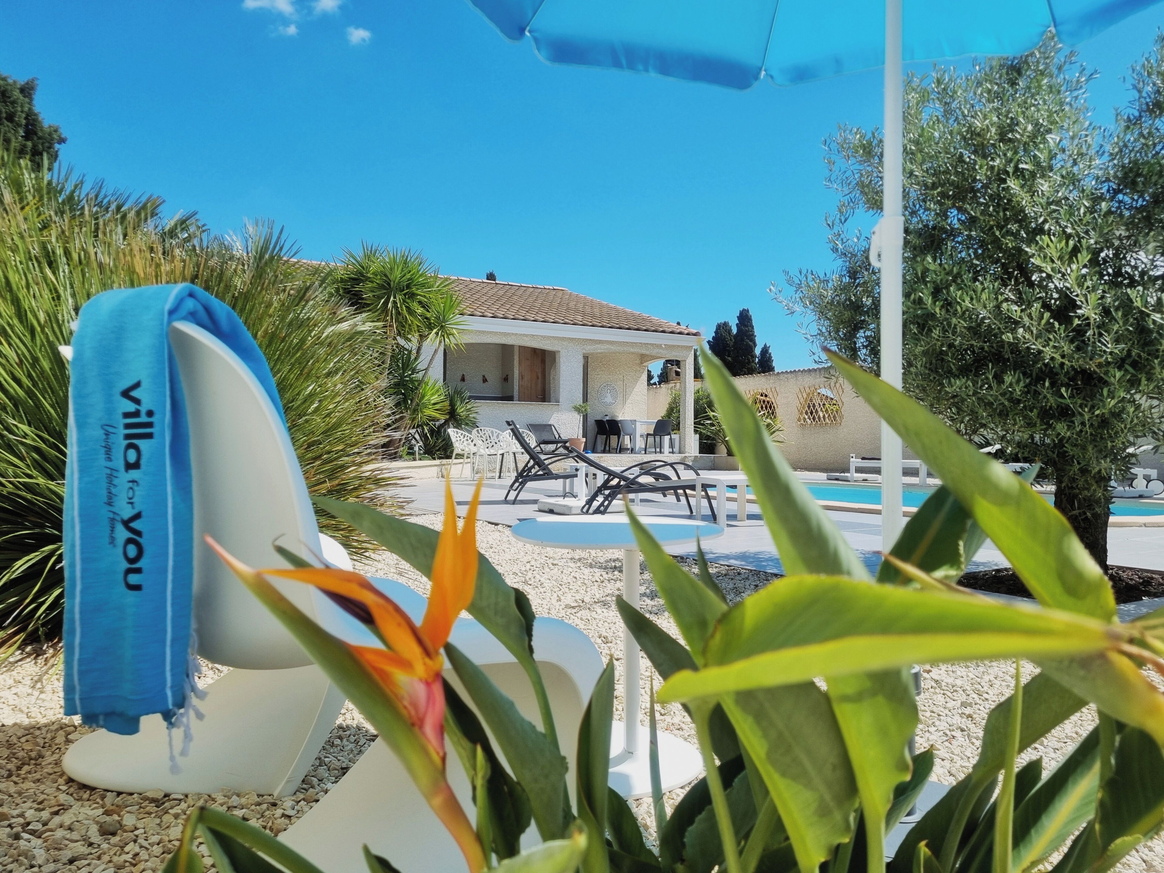 A pool area with lounge chairs and a covered seating area.