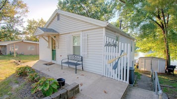 A small, single-story building with a porch, a bench, and a sign that reads 'Lake Life.'
