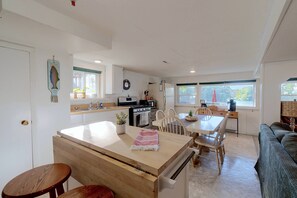 Une cuisine moderne avec un îlot central, des chaises en bois et une table à manger.