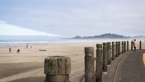A coastal walkway with a stone railing, leading to a sandy beach. - Oceanic Mirage - Newly Remodeled Family Friendly Ocean View (Newport)