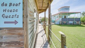 Une structure en bois sur laquelle est apposée une pancarte indiquant « da Boat House Guests » et une flèche pointant vers la droite.