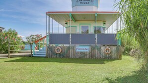 Un petit bâtiment en forme de bateau, avec une enseigne indiquant « da Boat House » et « Bienvenue » sur la façade.