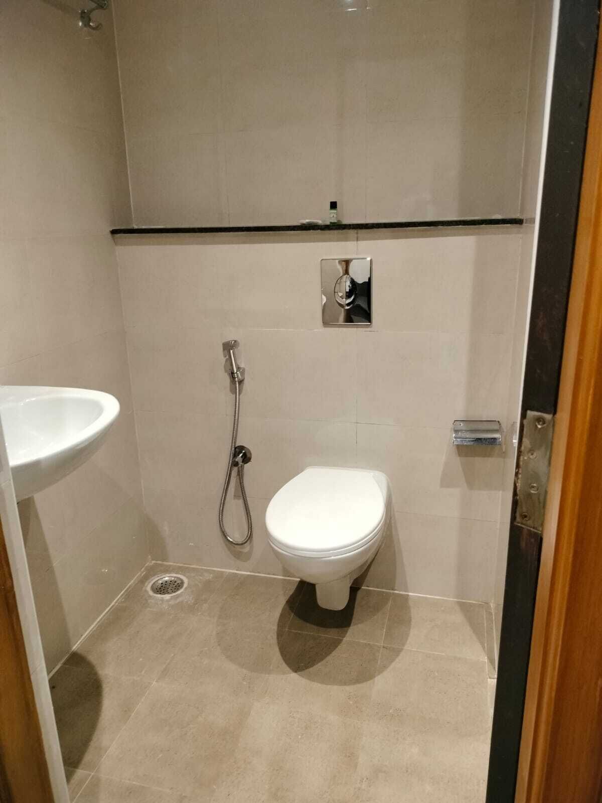 A small, modern bathroom with a toilet, a shower, and a sink.