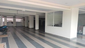 A spacious corridor with tiled flooring, white walls, and a ceiling with recessed lighting. - Hotel Paramount (Visakhapatnam)
