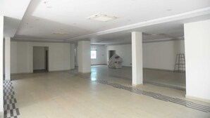 A spacious, empty interior with high ceilings and a central column, featuring a checkered floor pattern and a ladder against the wall. - Hotel Paramount (Visakhapatnam)