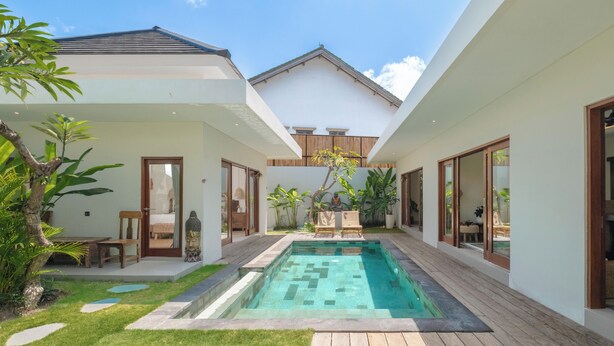 A modern house with a swimming pool, wooden deck, and lush greenery. - Villa Lange 2 by Villa Finder (Seminyak)