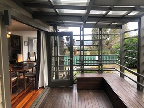 A wooden deck with a glass door leading to a garden.