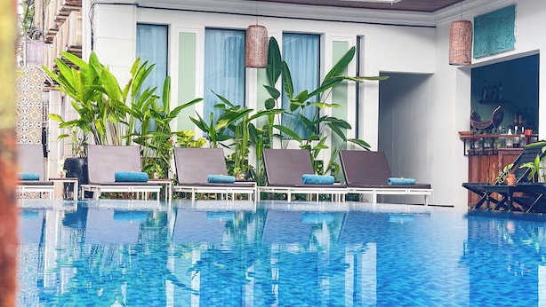 Ein Poolbereich mit Liegestühlen und Blumentöpfen.