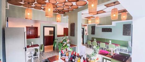 A hotel lobby with a reception desk, seating area, and a ceiling with circular wooden panels.