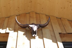 Une structure en bois ornée d’un grand crâne de taureau fixé au mur.