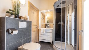 Ein modernes Badezimmer mit Toilette, Waschbecken und einer Duschkabine.