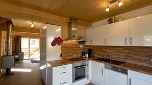 A modern kitchen with white cabinets, a stainless steel oven, and a coffee maker.