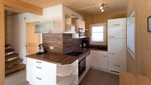 Une cuisine compacte avec des meubles en bois, une cuisinière encastrée et une fenêtre.