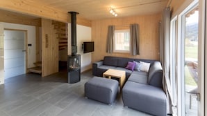 Un salon moderne avec un canapé, un pouf et une cheminée.