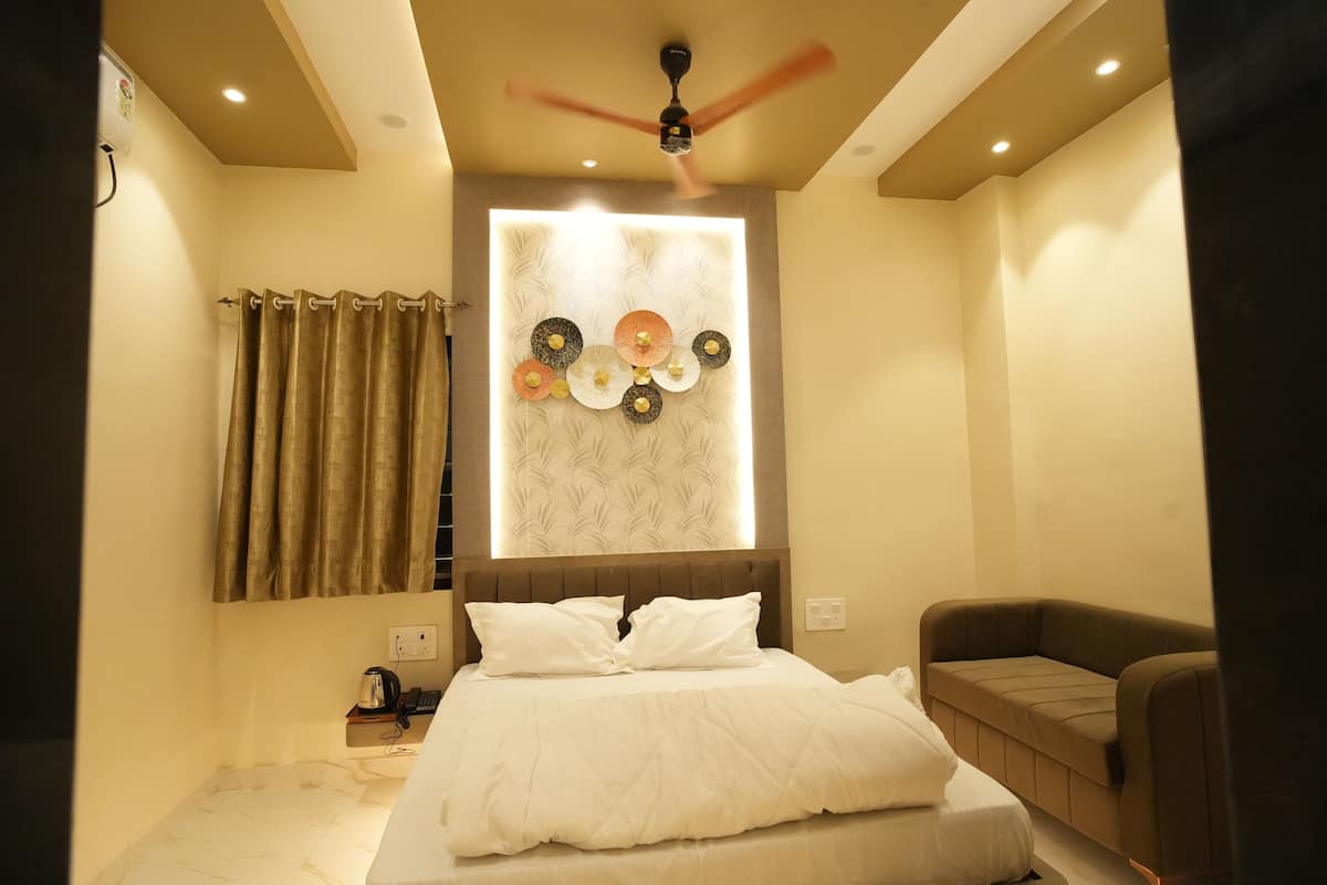 Un dormitorio moderno con cama, ventilador de techo, luz empotrada en la pared y un panel decorativo.